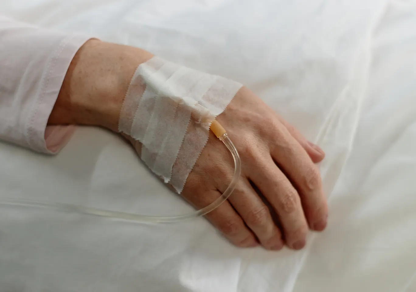 Kroplówki witaminowe Chełmno: dłoń z podłączoną kroplówką w spokojnym kadrze